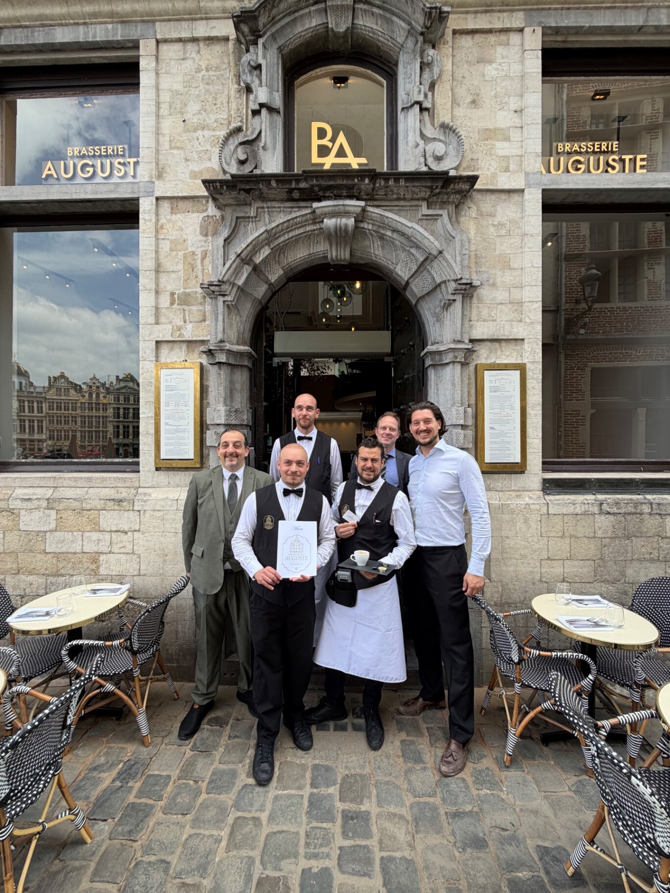 L'équipe de la Brasserie Auguste posant devant l'entrée du restaurant Grand-Place de Bruxelles le jour de l'ouverture, 15 juin 2026