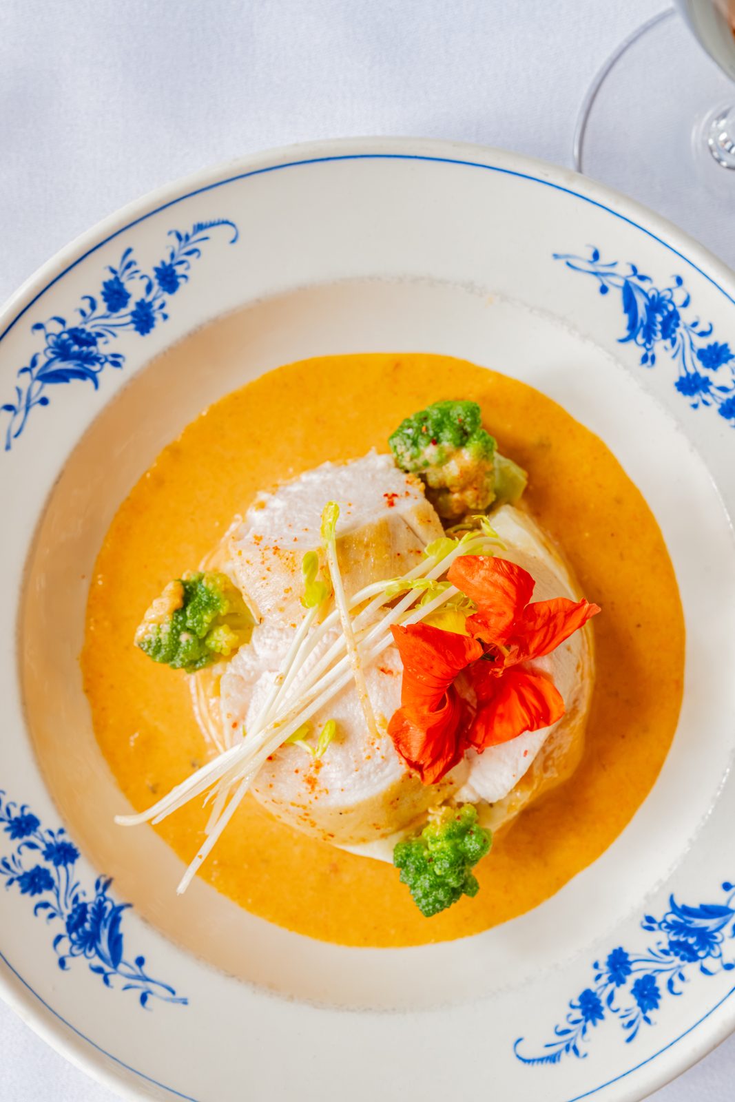 Fish dish with saffron sauce and nasturtium flower