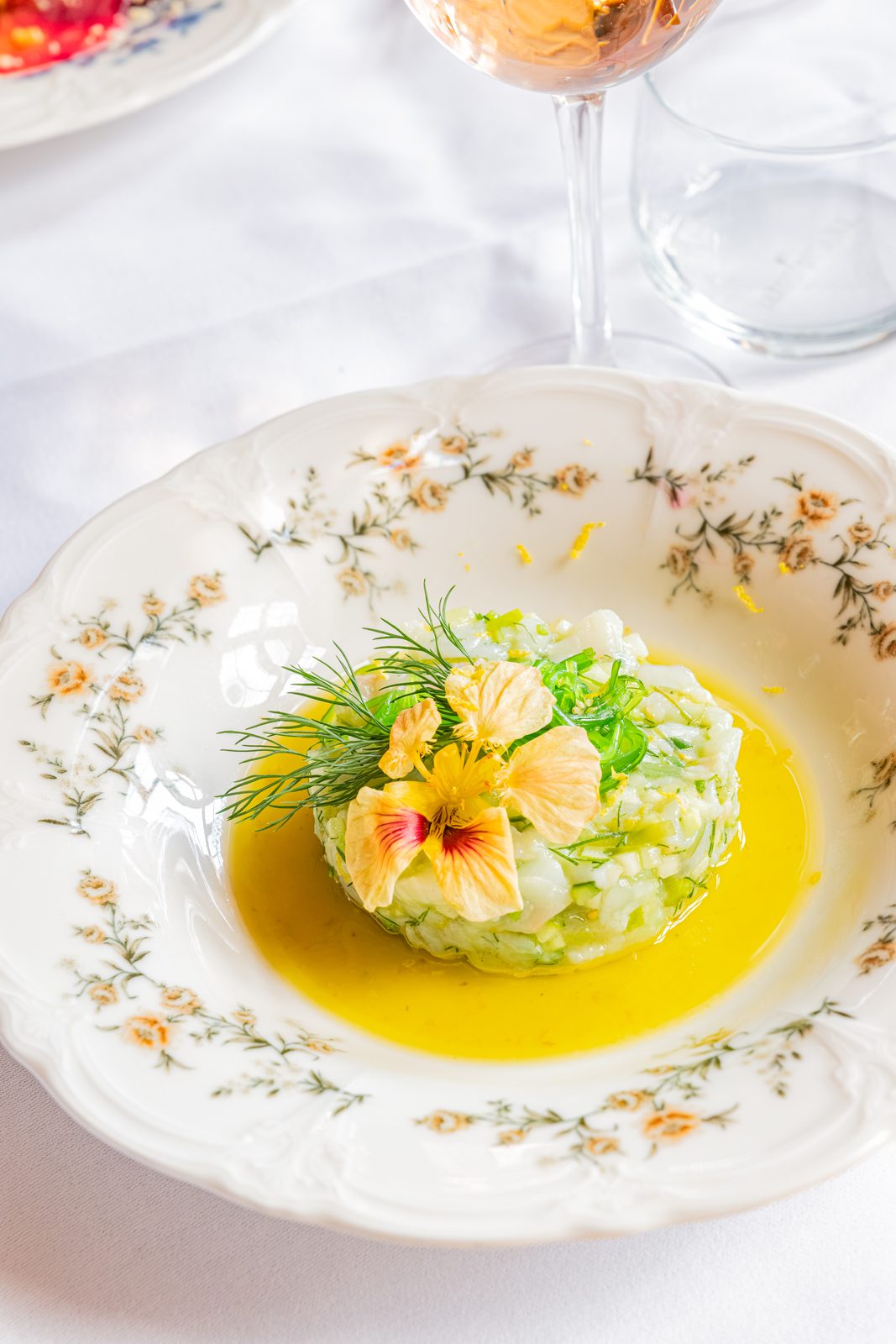 Fresh starter with edible flowers served on a floral earthenware plate