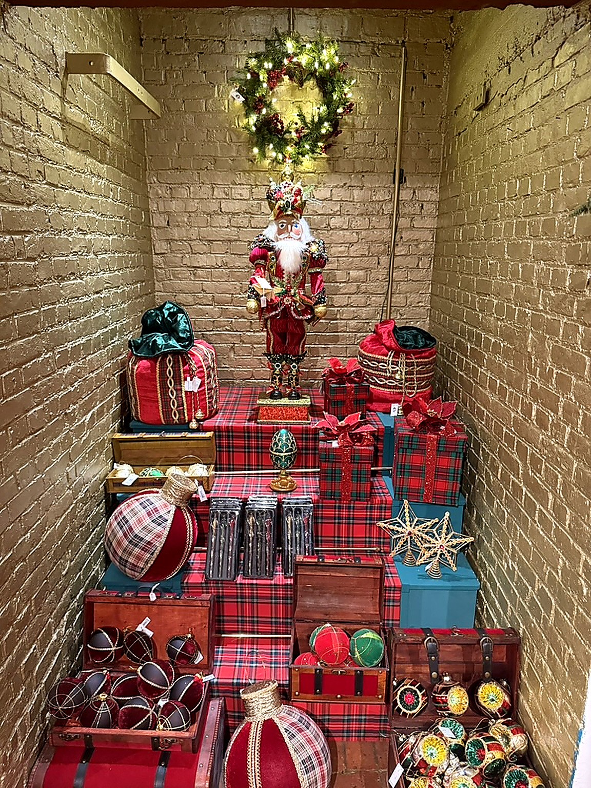 Escalier habillé de tartan rouge avec casse-noisette géant et coffres remplis de boules de Noël Escalier habillé de tartan rouge avec casse-noisette géant et coffres remplis de boules de Noël