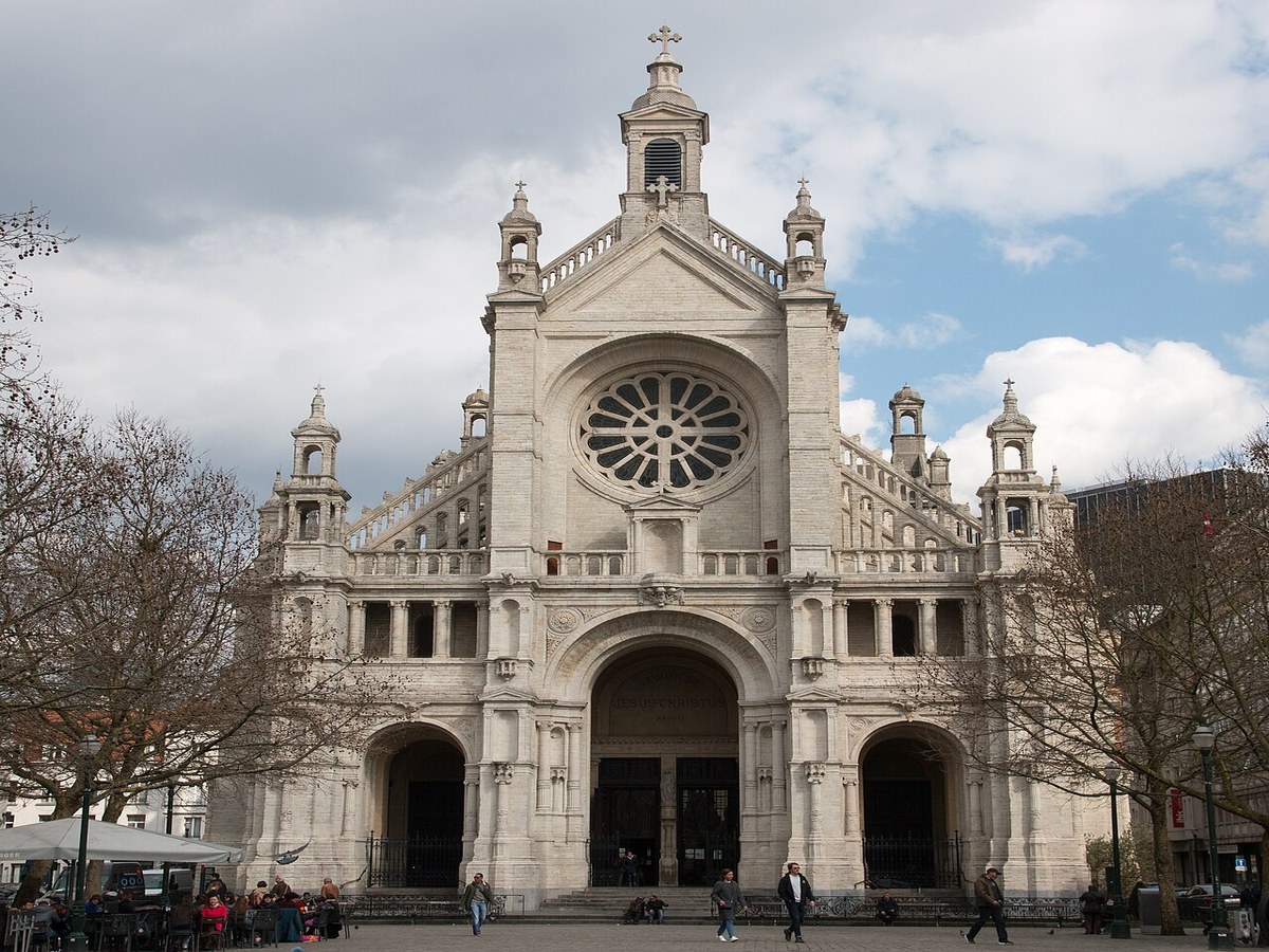 © Chris Olszewski · Wikimedia Commons · CC BY-SA 4.0 — L’église Sainte-Catherine vue depuis la place, 2025 L’église Sainte-Catherine à Bruxelles vue depuis la place, façade de pierre claire sous un ciel bleu, passants sur les pavés