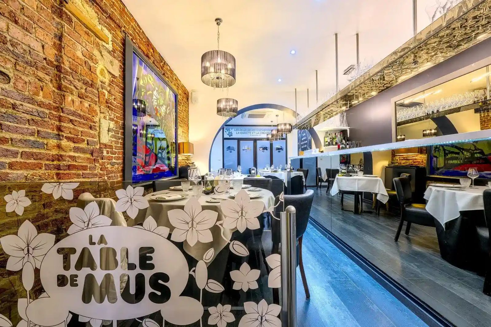 The dining room of La Table de Mus: brick, arches and white tablecloths