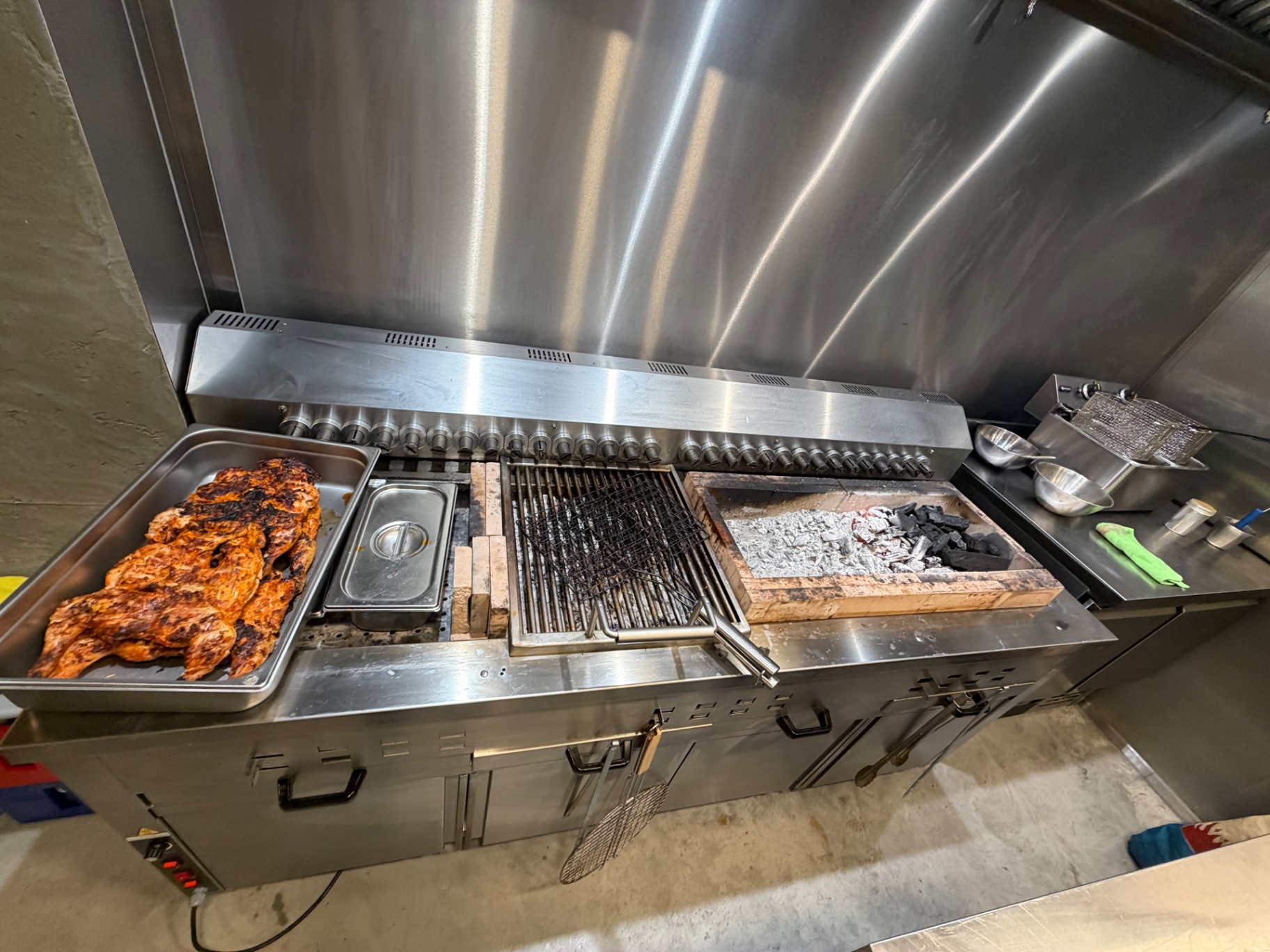 Le Kanun en action : brasero charbon de bois, poulets marinés grillés au feu chez Lafeh Kanun Bruxelles