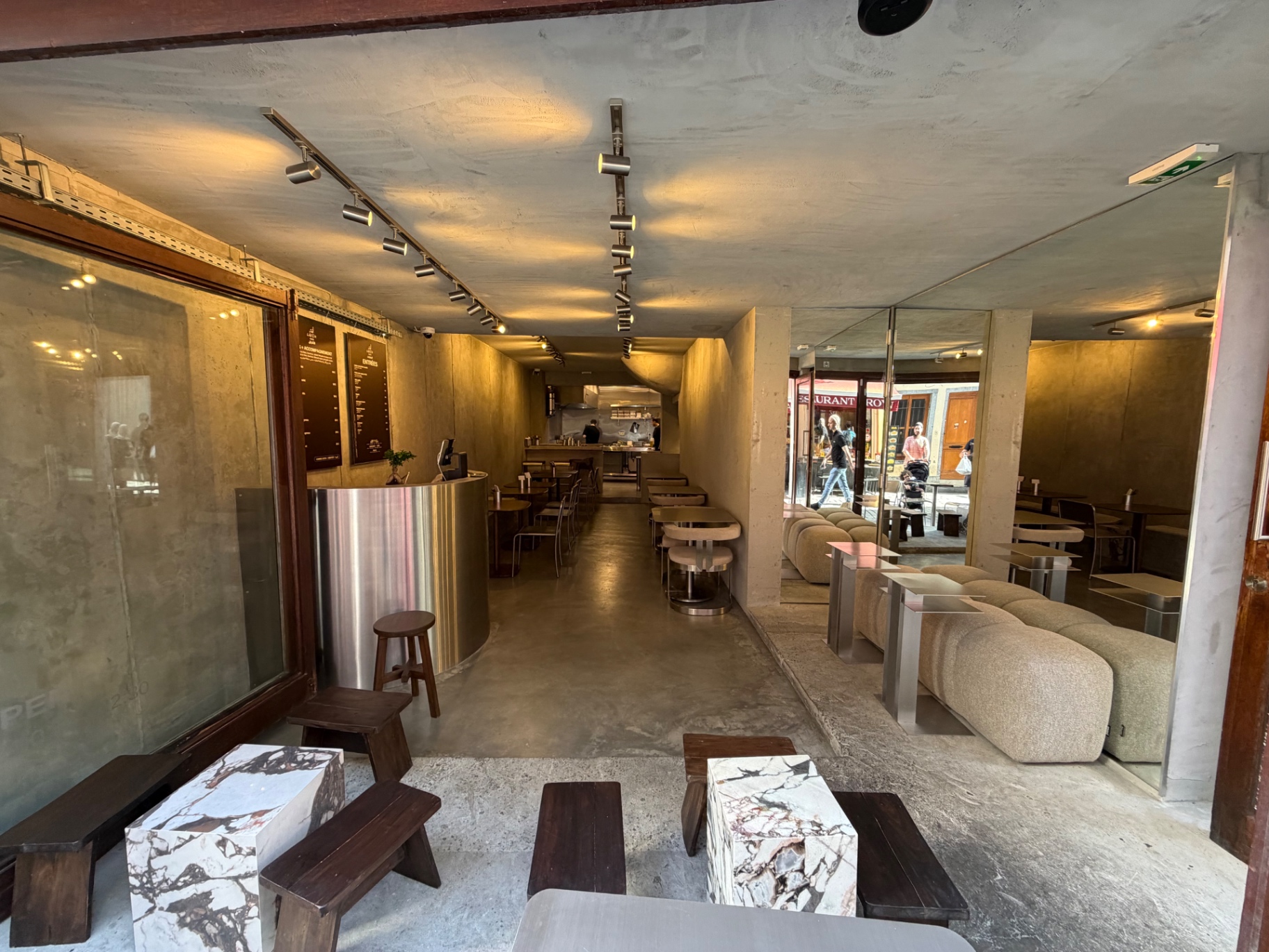 Entrée de Lafeh Kanun, îlot Sacré — béton brut, marbre calacatta, banquettes bouclées et comptoir en inox brossé