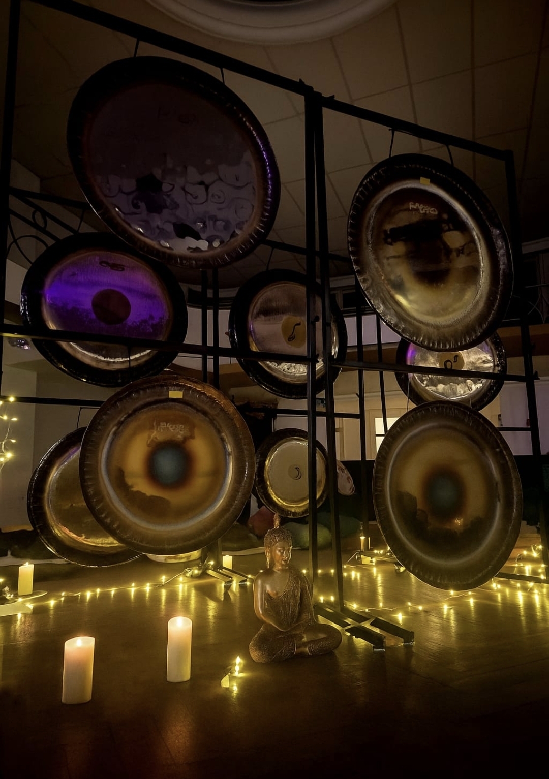 Mur de gongs et Bouddha aux bougies