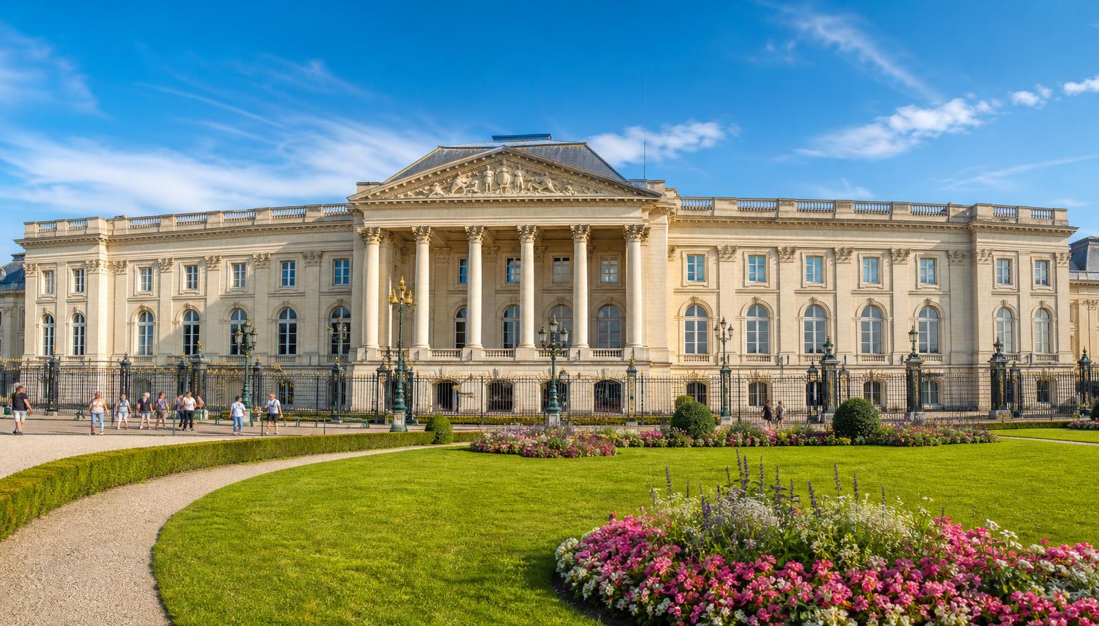 Façade néoclassique du Palais royal de Bruxelles vue de la place des Palais, colonnes corinthiennes, fronton sculpté et parterres fleuris sous un ciel bleu