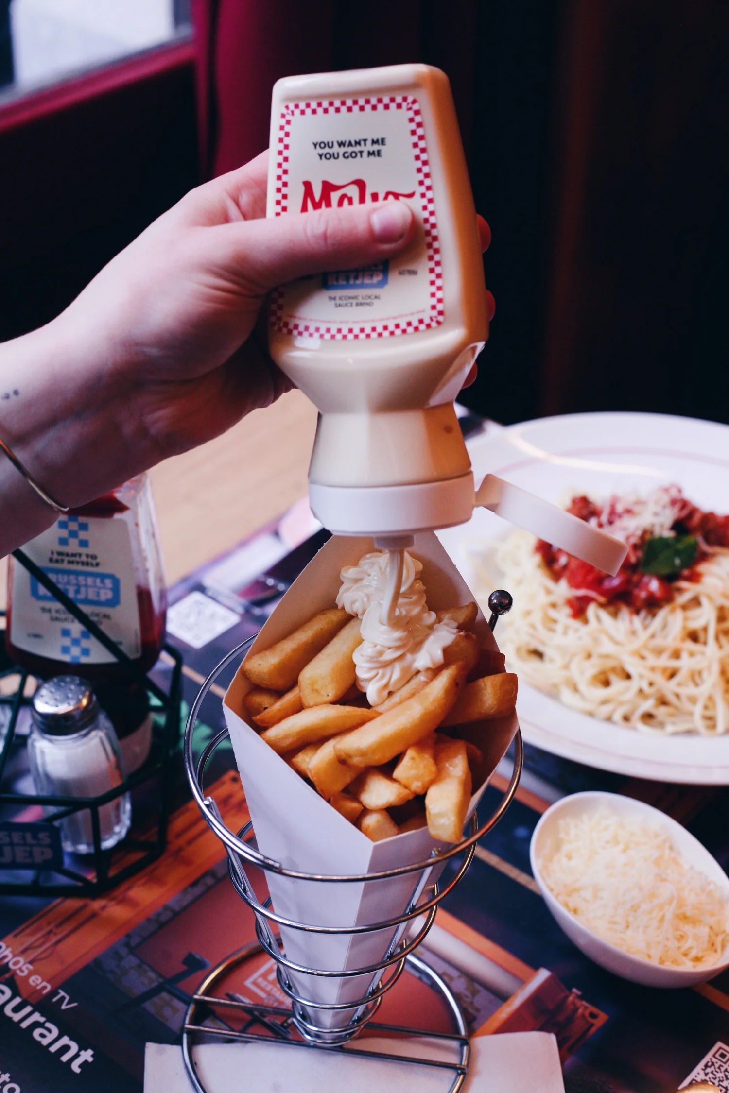 A cone of fries with mayonnaise on a table at Plattesteen in Brussels