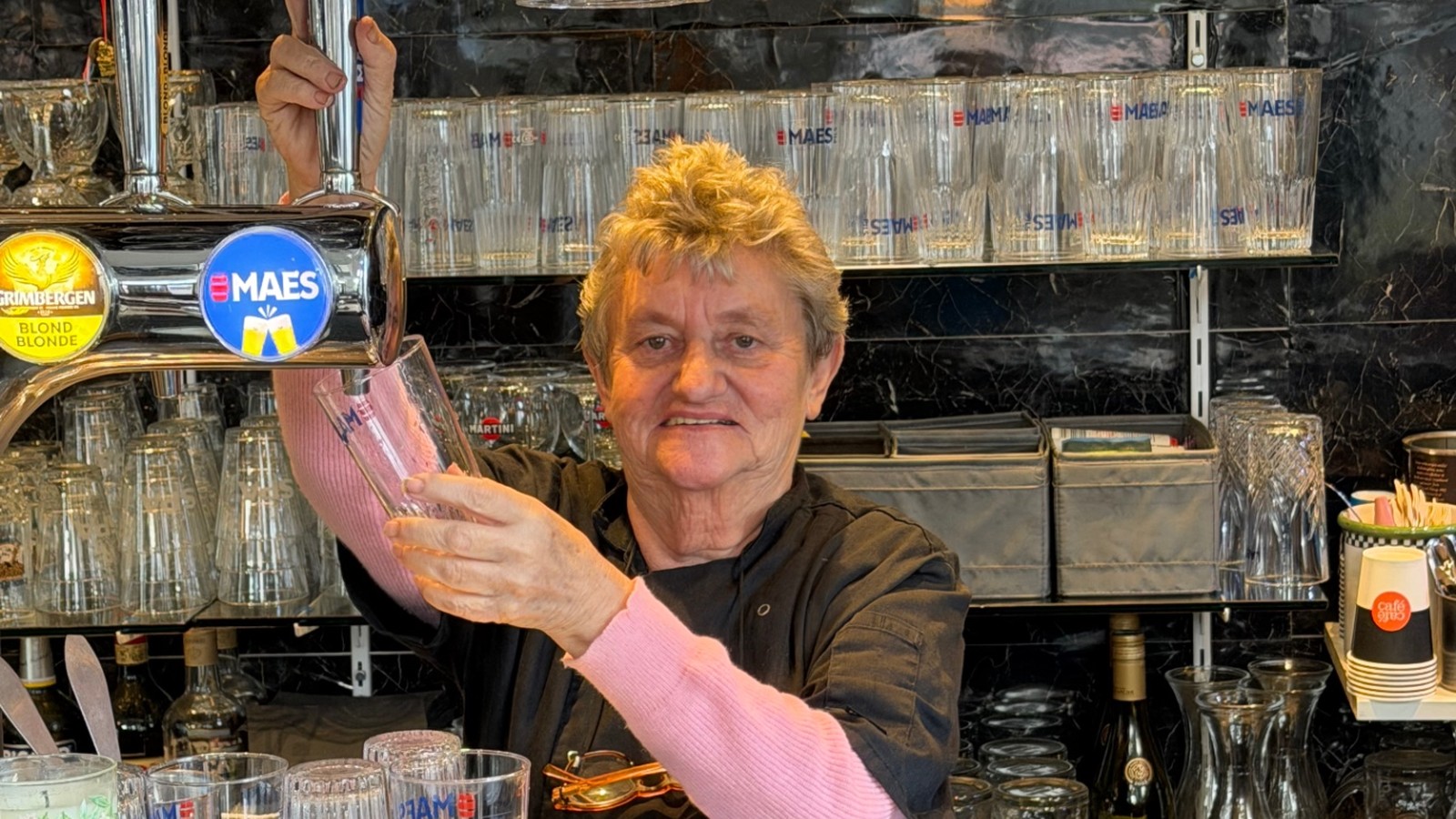 Portrait de Marianne au comptoir du Saint d’Hic III, place Rouppe. Marianne derrière le comptoir du Saint d’Hic, place Rouppe à Bruxelles, servant une bière à la pompe