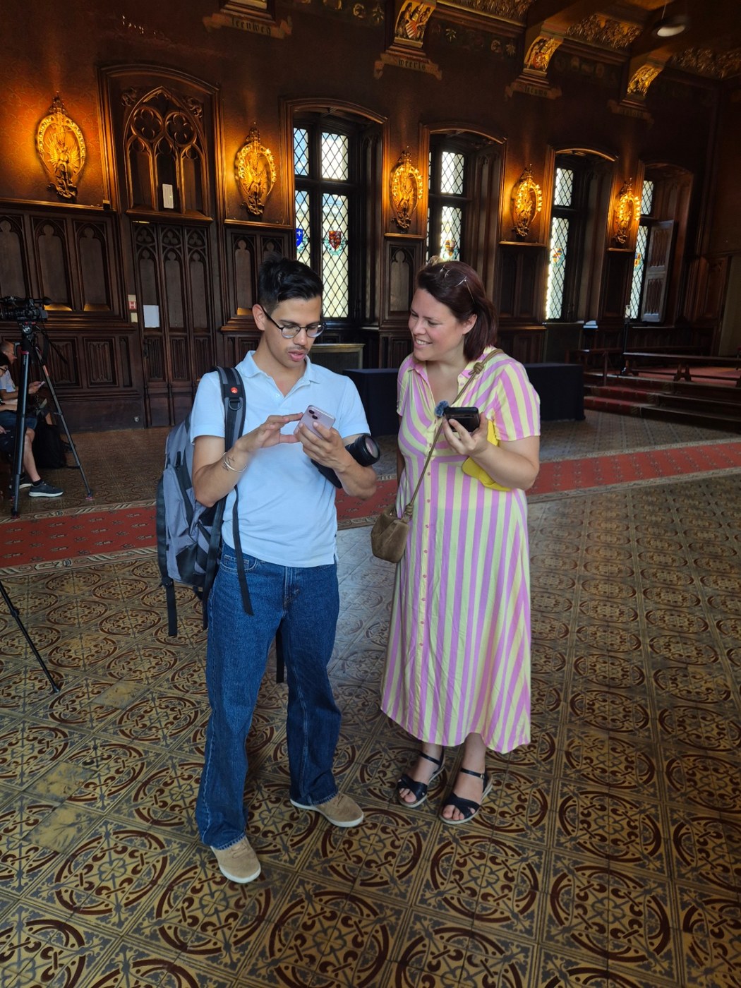 Julie van Xplore.bruxelles en videomaker Victor in de gotische zaal van het Brusselse stadhuis op 13 augustus 2026